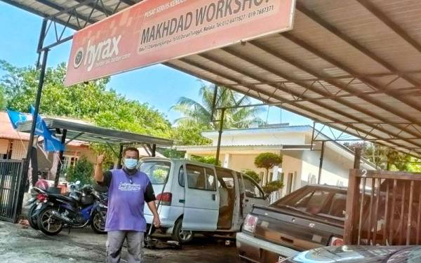 Shikh Muhammad Makhdad berdiri di hadapan bengkel kereta miliknya yang terletak di Gangsa, Durian Tunggal.